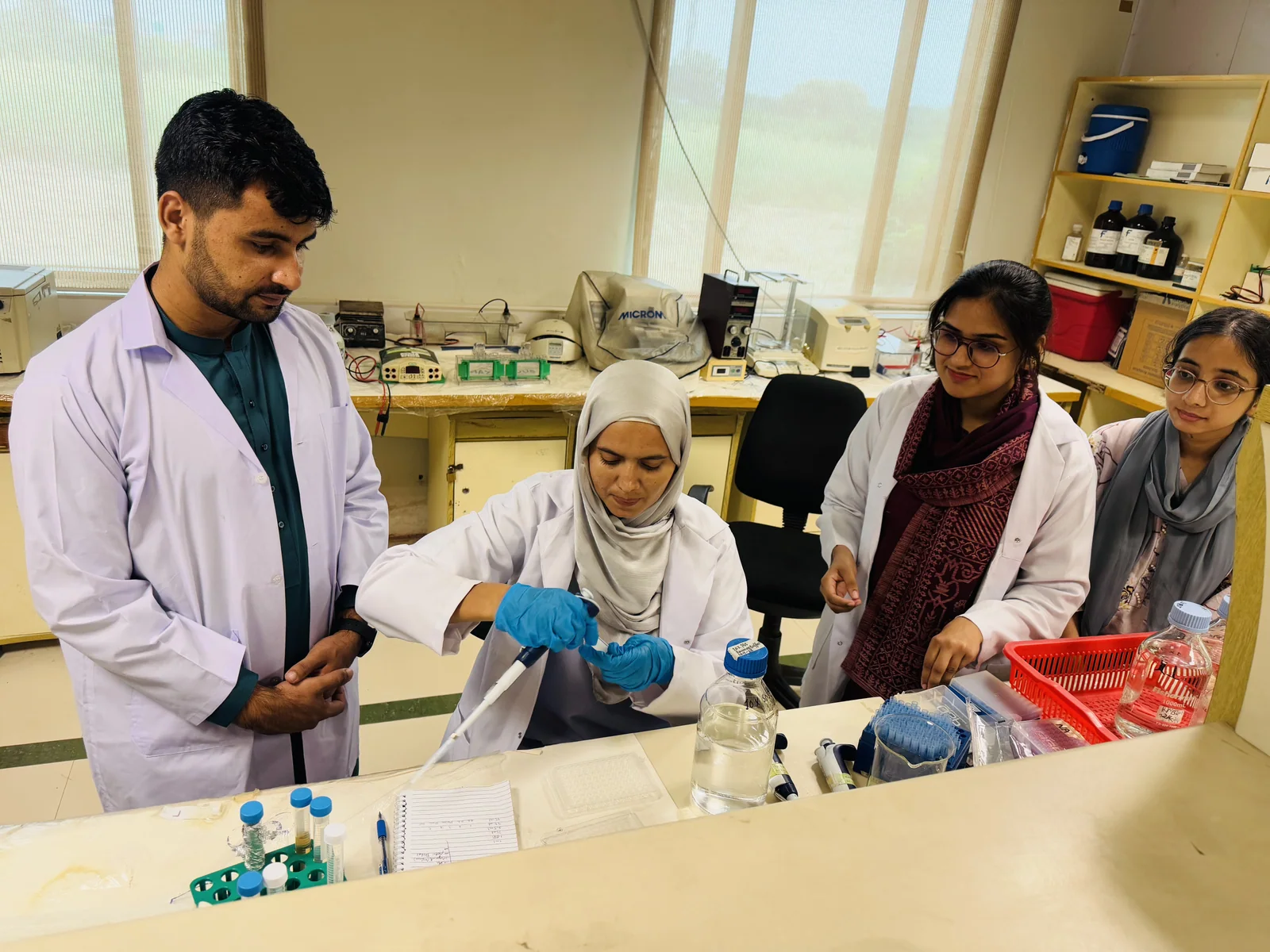 A CEMB supervisor demonstrating a laboratory technique to M.Phil students
