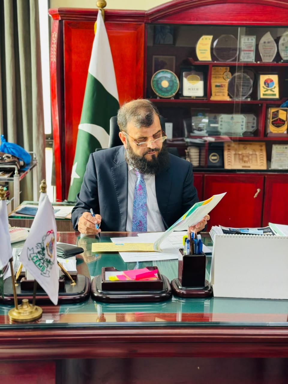 Prof. Dr. Moazur Rahman reviewing documents in the CEMB Director&rsquo;s office